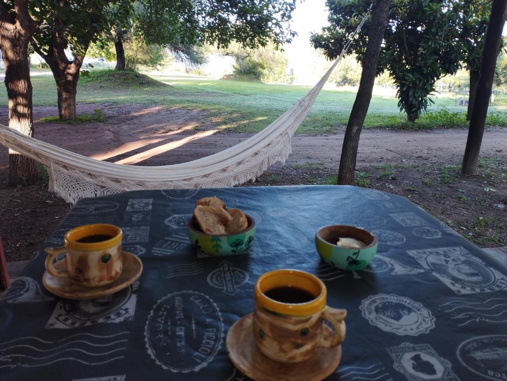 una mesa con tazas y tazas de café. en La Cabañita Córdoba en Villa Rumipal