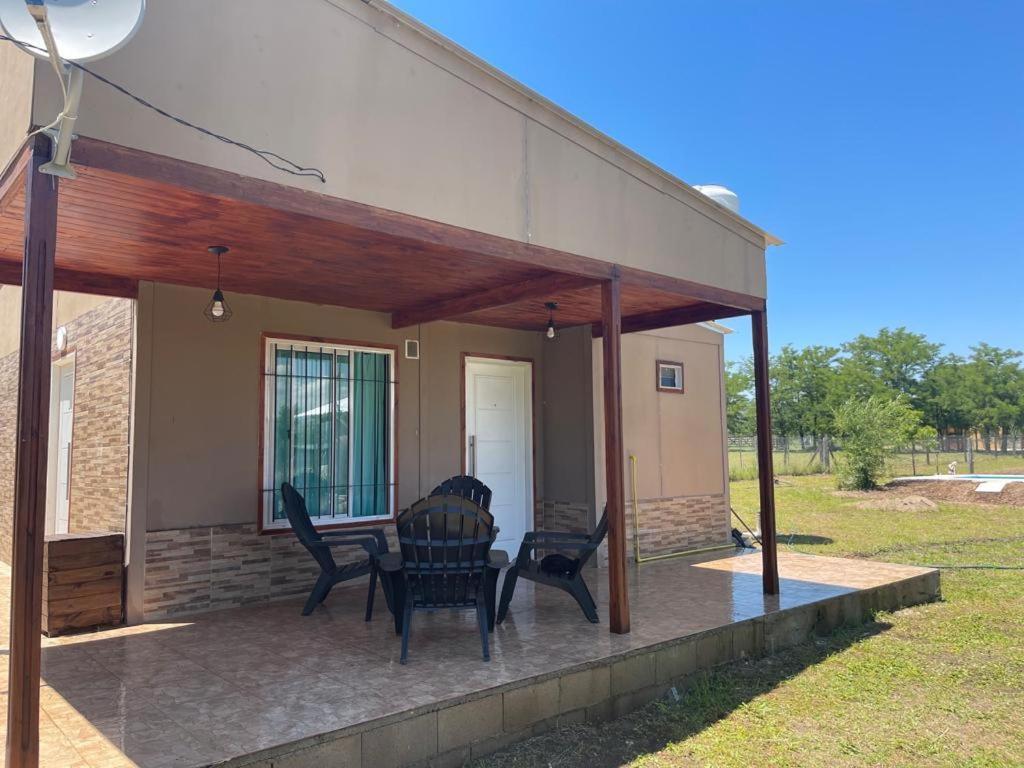 un patio con sillas y una mesa en una casa en CABAÑA EN CALAMUCHITA CORDOBA en Villa Ciudad Parque