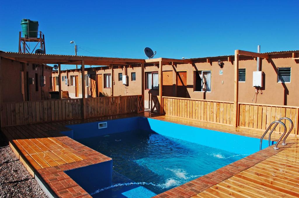 a swimming pool with a blue and white tub at Hostal Pablito in San Pedro de Atacama
