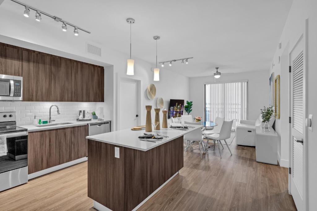 uma cozinha com balcões brancos e armários de madeira em Modern 2 Bed in the Heart of Doral Free Parking em Hialeah Gardens