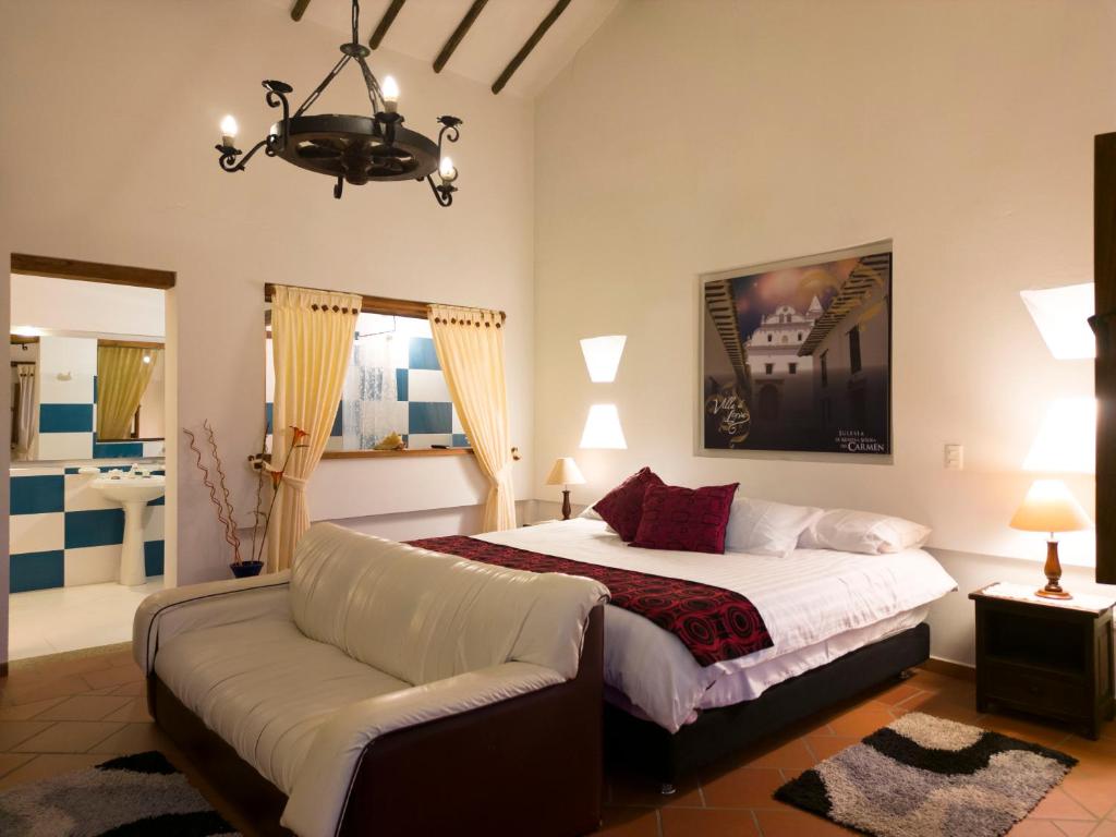 a large bedroom with a bed and a couch at Cabañas Villa Encanto in Villa de Leyva