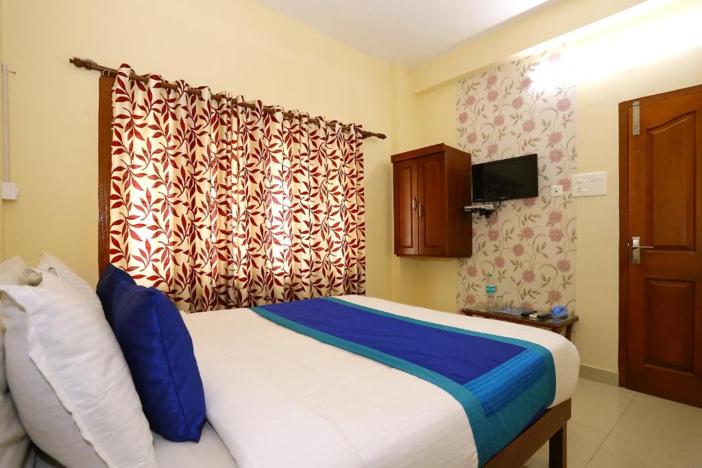 OYO Flagship 5202 Hotel Pearl Malabar tesisinde bir odada yatak veya yataklar