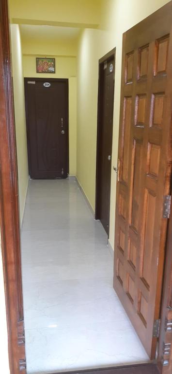 an empty room with two doors and a corridor at Varadhar Guest House in Kanchipuram