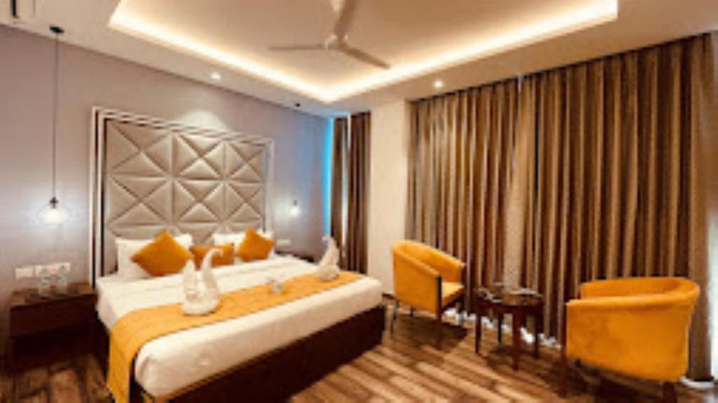 Pokój hotelowy z dużym łóżkiem i krzesłem w obiekcie The Vilana Luxurious Hotel in Rishikesh , Uttarakhand w mieście Rishikesh