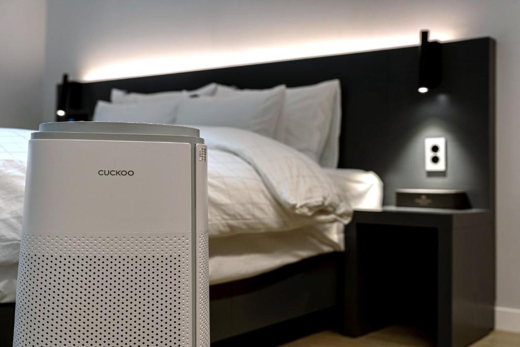 a bedroom with a bed with a computer on the floor at Hound Hotel Mokpo Peace Plaza in Mokpo