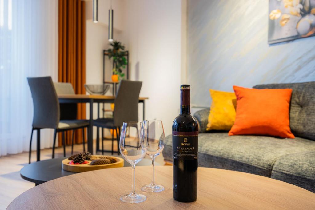uma garrafa de vinho e dois copos de vinho numa mesa em Lynx Apartment em Mavrovo