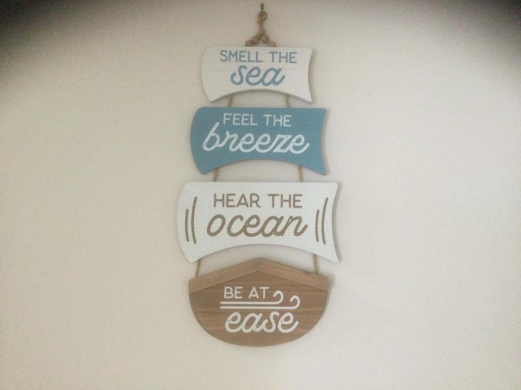 a group of signs hanging on a wall at 1 Tree Escape in Wooli