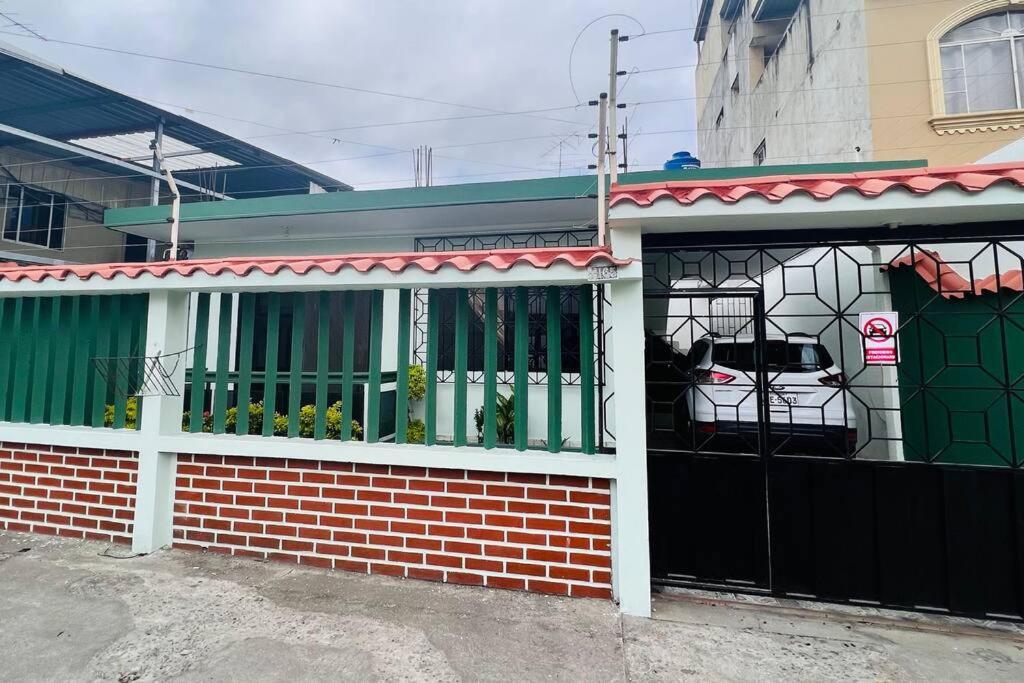 a house with a black gate and a garage at Amplia, independiente y segura vivienda de 2 habitaciones in Machala