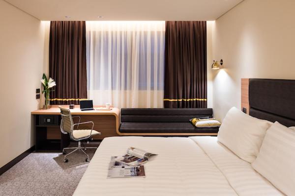 a hotel room with a bed and a desk at Camlux Hotel in Hong Kong
