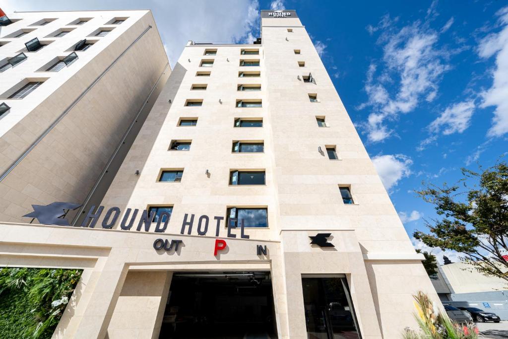 a tall white building with a hotel sign on it at Hound Hotel Mokpo Peace Plaza in Mokpo