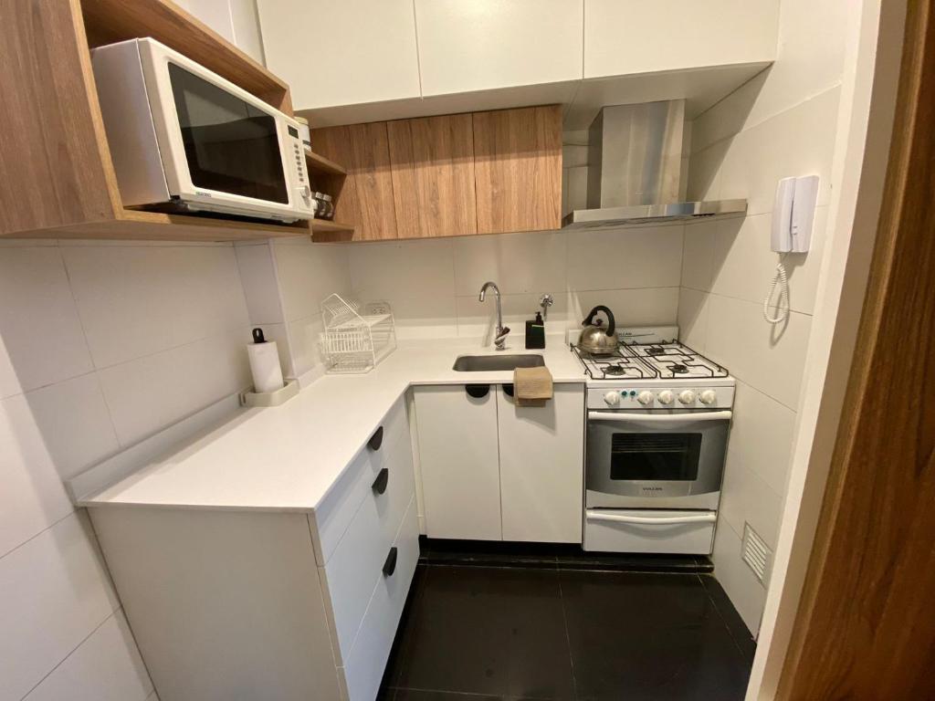 a small kitchen with a stove and a microwave at Apartamento Malabia in Buenos Aires