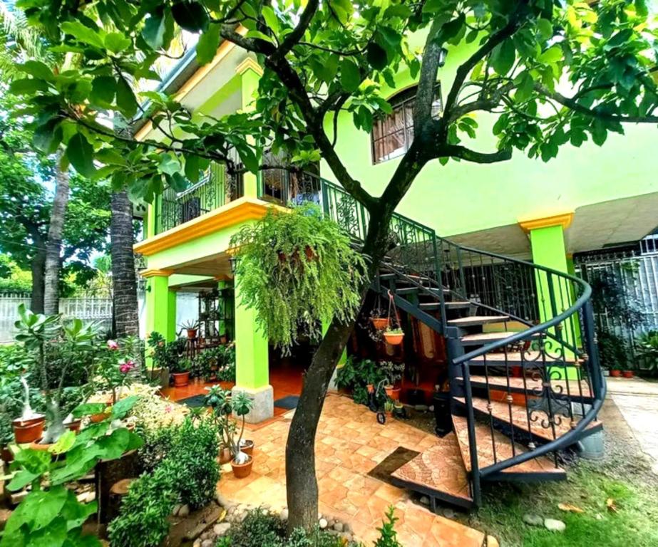 ein Haus mit einer Wendeltreppe in einem Garten in der Unterkunft Hostal San Antonio in León