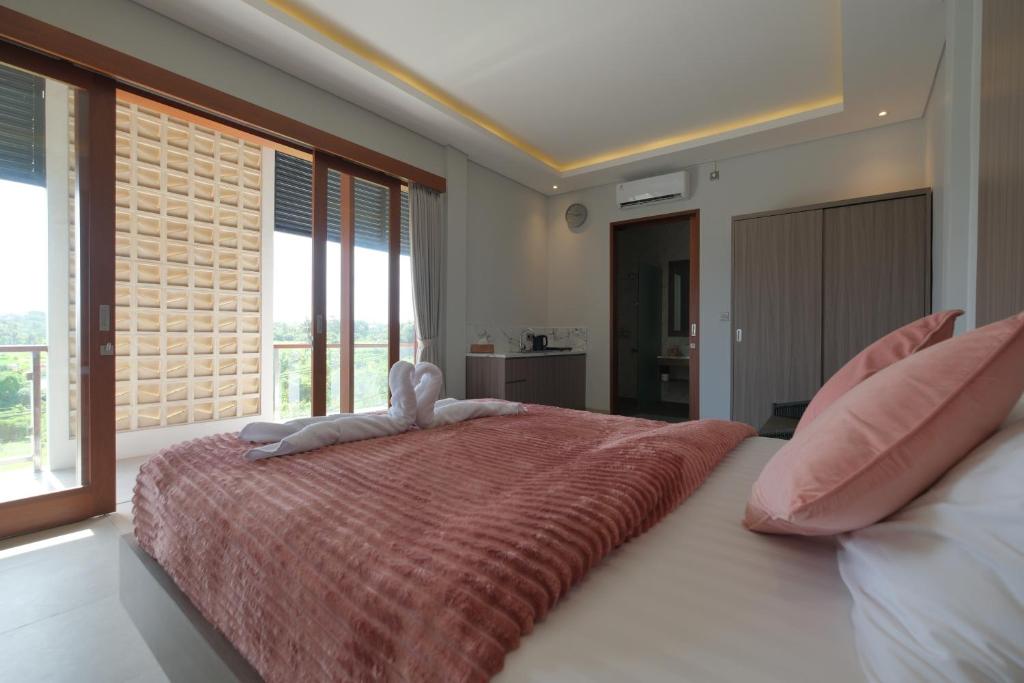 Un dormitorio con una cama grande con un animal de peluche. en Mesari Villa en Keramas