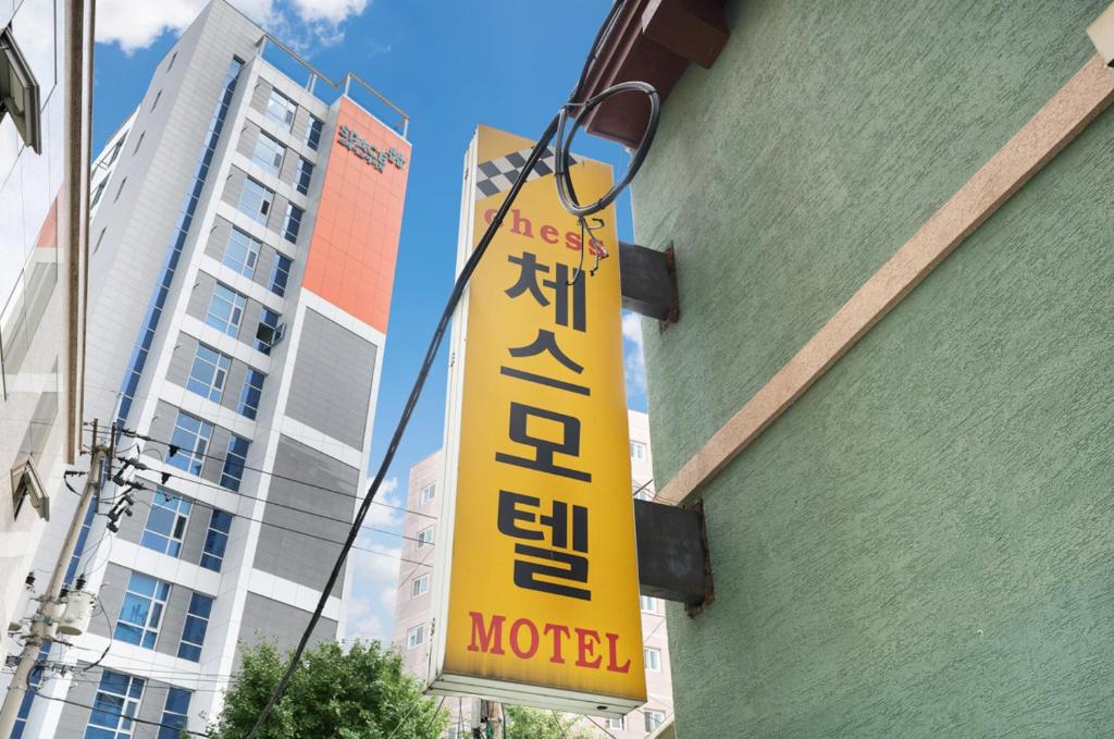 a yellow sign hanging from the side of a building at Chess Motel in Seoul