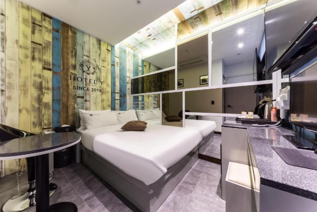 a bedroom with a large white bed and a table at Y Hotel in Seoul