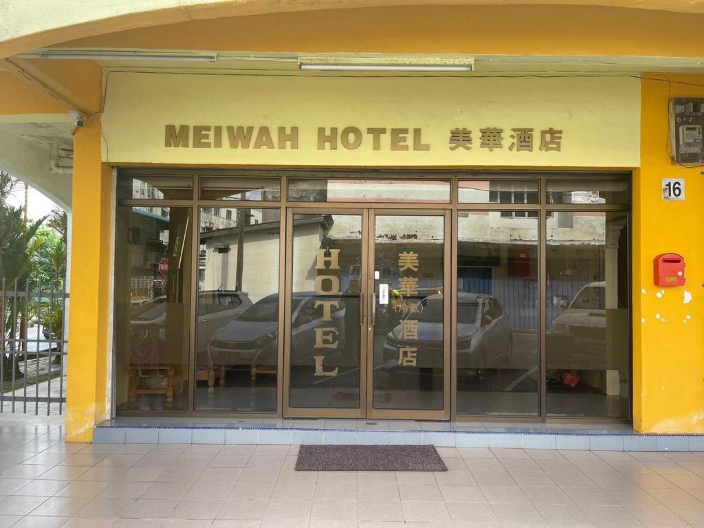 a mexican hotel with cars reflecting in the windows at OYO 90914 Hotel Mei Wah in Kampong Selanchor