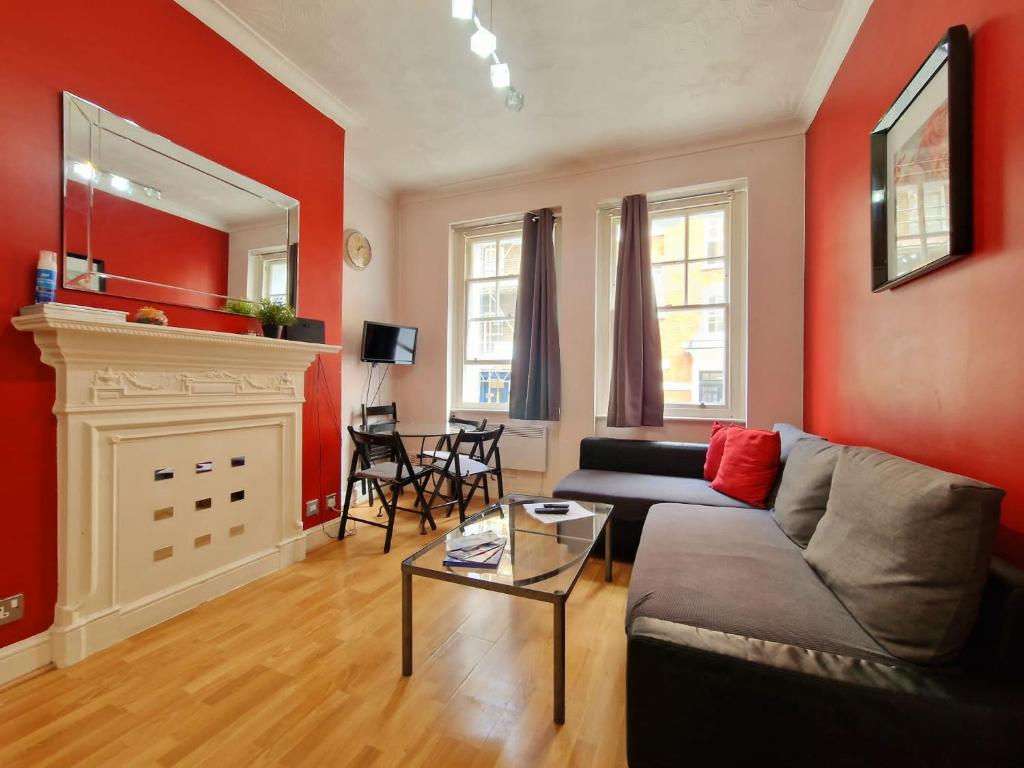 a living room with a couch and a fireplace at Cozy Flat, 5 minute walk to Oxford Circus in London