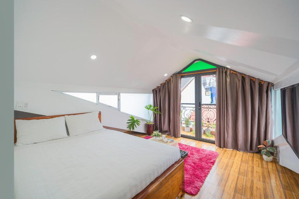 ein Schlafzimmer mit einem Bett und einem großen Fenster in der Unterkunft Khách Sạn Lối Về Đà Lạt in Da Lat