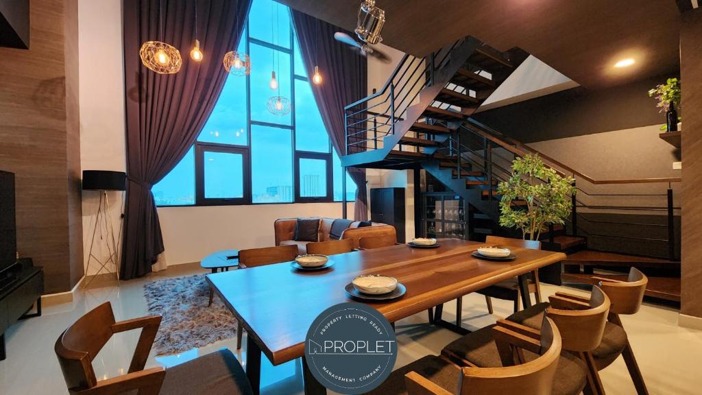 a dining room with a table and a spiral staircase at Luxury Duplex Suite 4 pax Netflix Wifi Selayang KL in Batu Caves