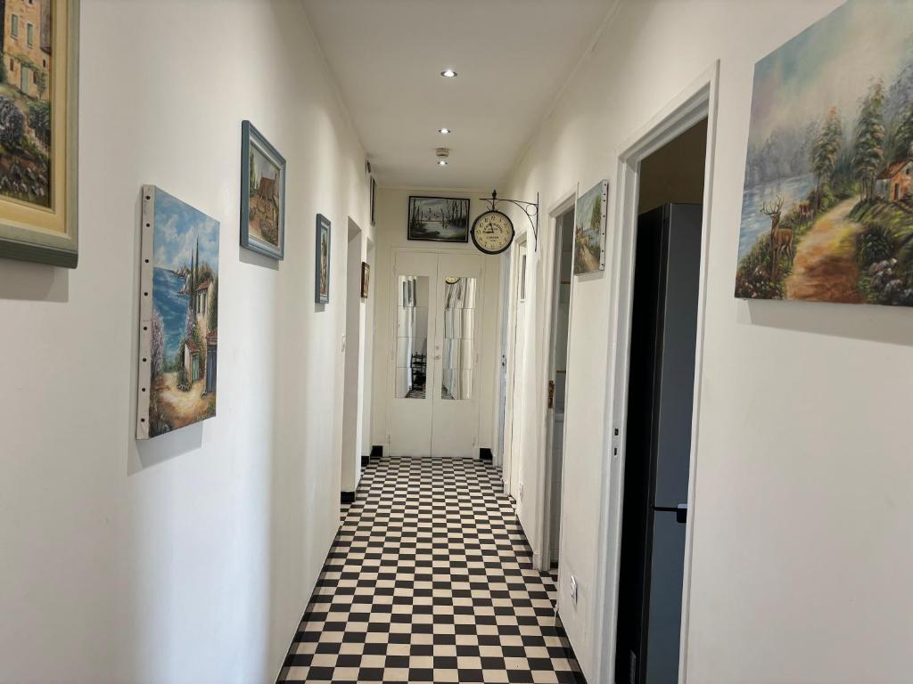 um corredor com um piso xadrez e um relógio na parede em Brinette Room em Toulon