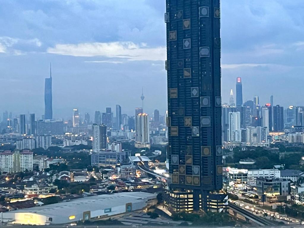 ein hohes Gebäude mit einer Stadt im Hintergrund in der Unterkunft Eko Cheras 时尚复式公寓loft,两室一厅 in Kuala Lumpur