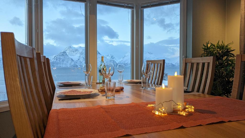 een eettafel met uitzicht op de oceaan bij Villa Lyngenfjord in Olderdalen