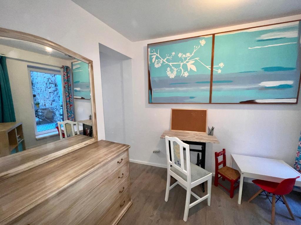 Zimmer mit einem Schreibtisch, einem Tisch und Stühlen in der Unterkunft Apartamento com pátio em frente praia in Paço de Arcos