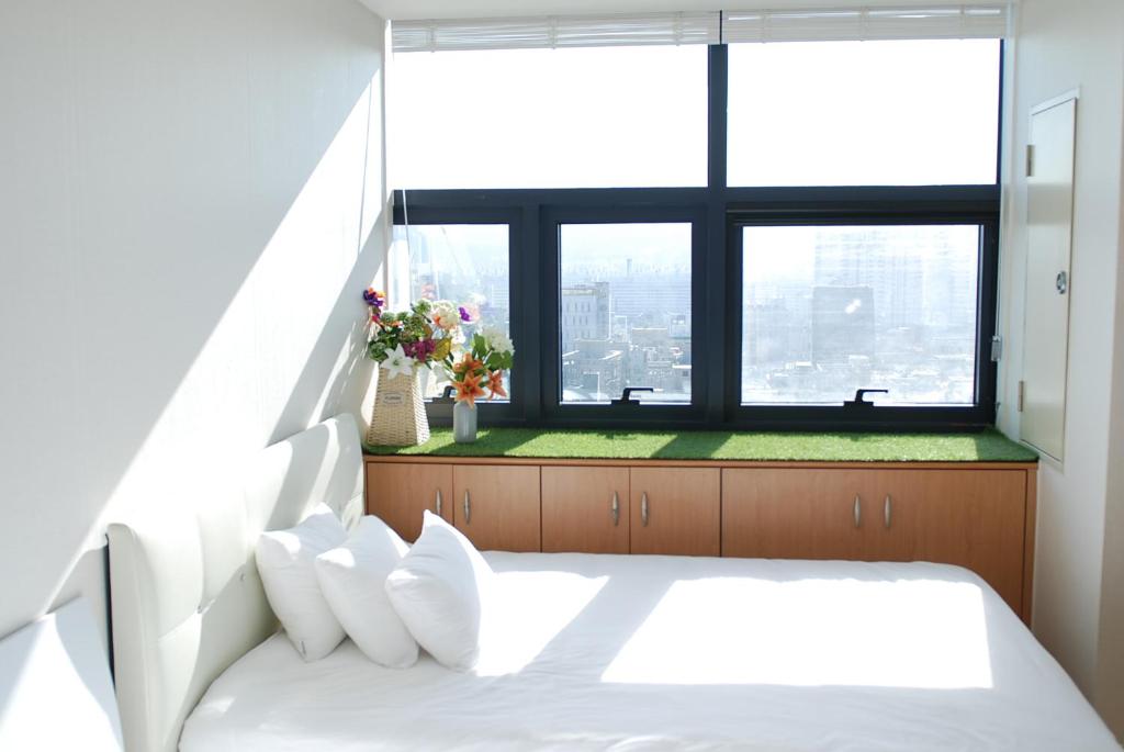 a bedroom with a white bed and a large window at Gangnam Coex in Seoul