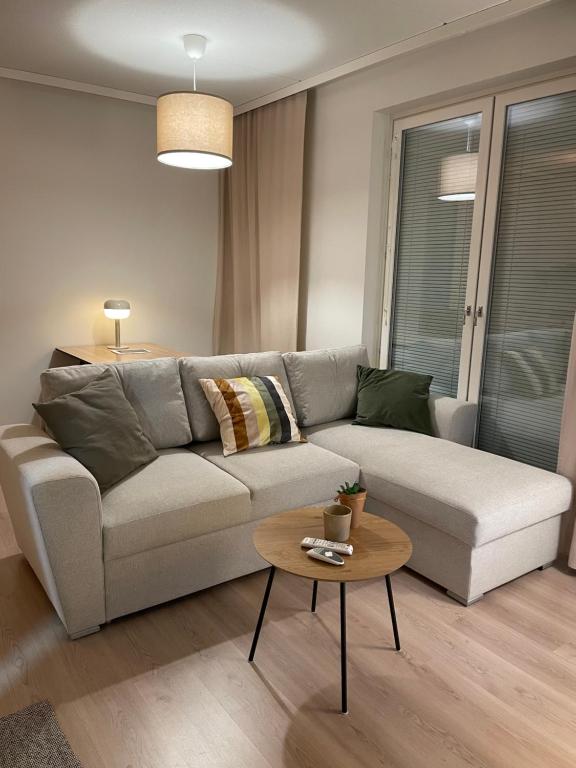 a living room with a couch and a table at Helsinki Airport Apartment in Vantaa