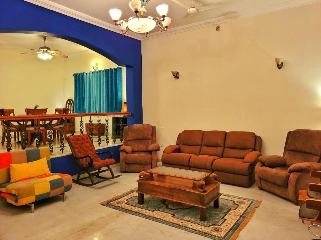 un soggiorno con divani, sedie e tavolo di Urban Escape Luxury Villa a Bangalore