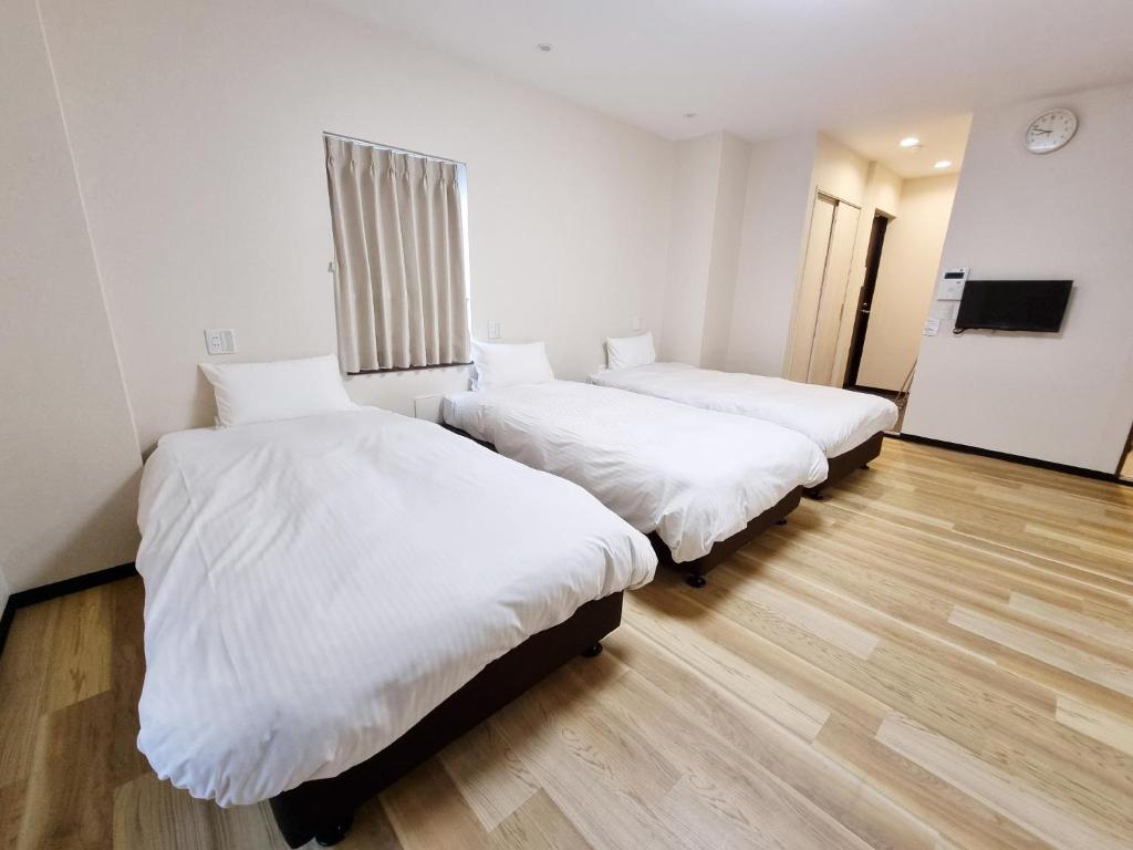 Posteľ alebo postele v izbe v ubytovaní KYU KYU HOTEL