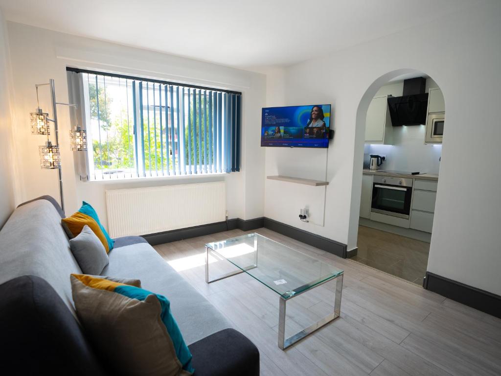 un soggiorno con divano e tavolo in vetro di Central Apartment 3 Beds Near Station Fee Parking a Farnborough