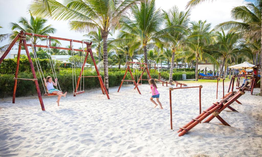 two girls playing on a playground on the beach at Cam Ranh Riviera Beach Resort & Spa in Cam Ranh