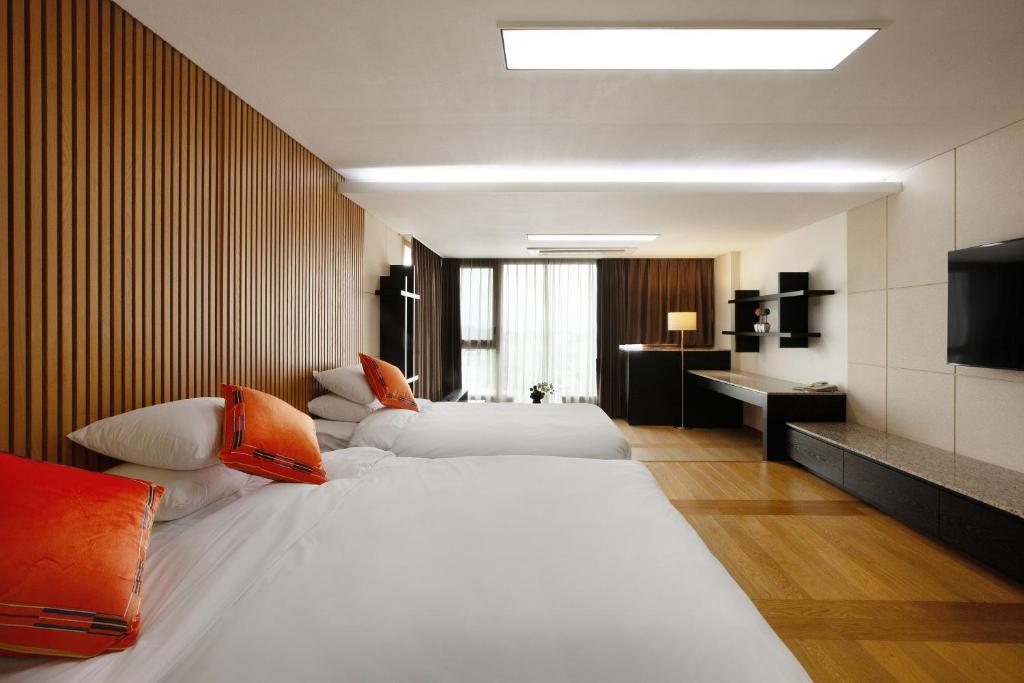 Postel nebo postele na pokoji v ubytování Shin Shin Hotel Jeju Ocean