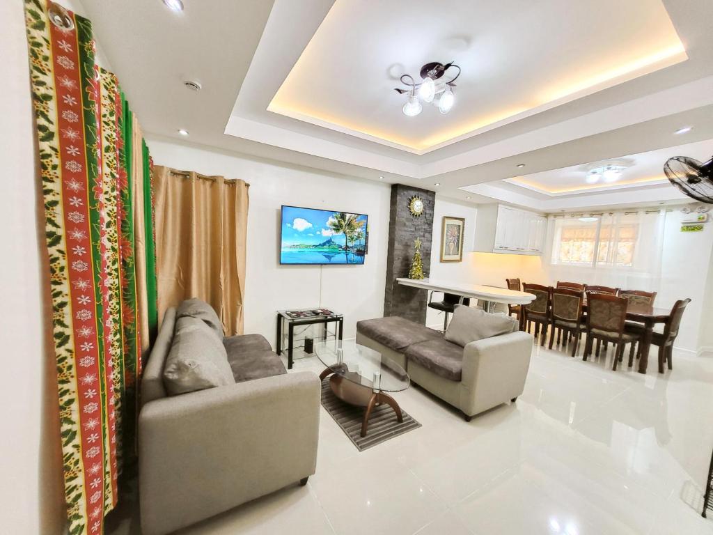 ein Wohnzimmer mit 2 Sofas und einem Klavier in der Unterkunft Golden Queen Suites in Baguio City