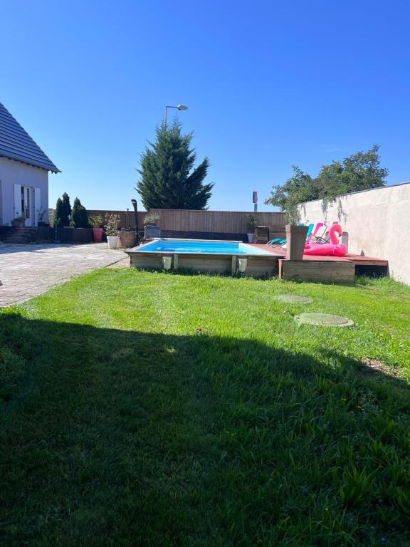 um quintal com uma piscina na relva em Maison avec piscine em Hoerdt