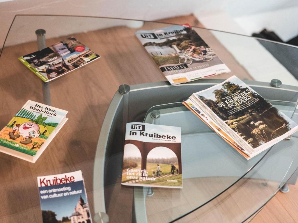 a glass table with magazines and books on it at Modern holiday home in Bazel with garden in Bazel