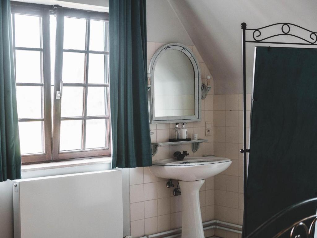 a bathroom with a sink and a mirror and a window at Modern holiday home in Bazel with garden in Bazel