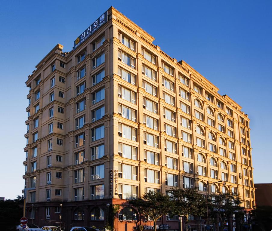 a large building with a blue sky at Shin Shin Hotel Jeju Ocean in Seogwipo