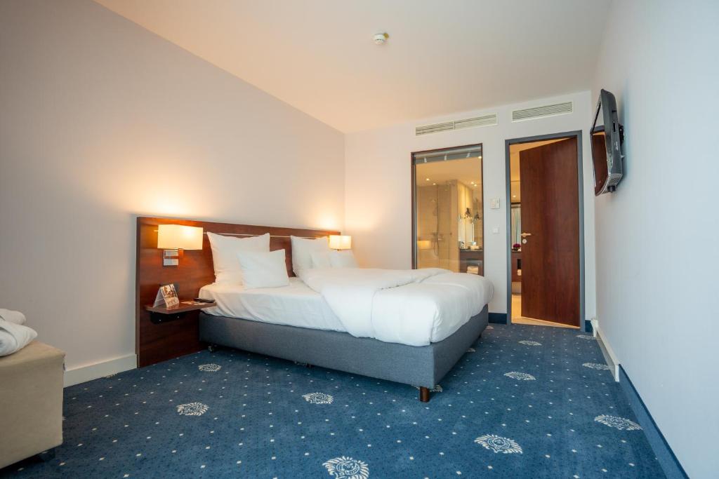 Ein Bett oder Betten in einem Zimmer der Unterkunft Hotel Vier Jahreszeiten Starnberg