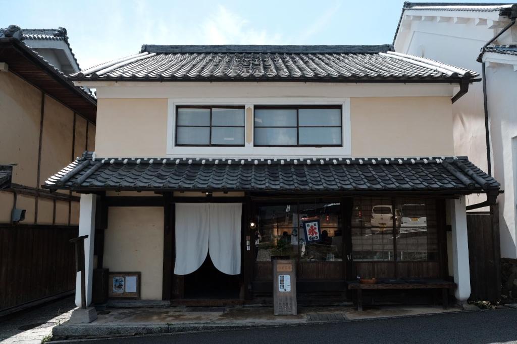 a building with a white curtain on the front at Hostel & Tatami Bar Uchikobare -内子晴れ- in Uchiko