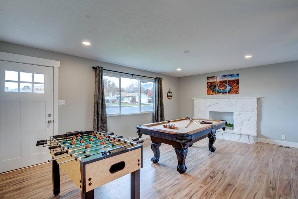 sala de estar con mesa de billar y chimenea en Comfortable Modern Home w/ Game Room, en American Fork