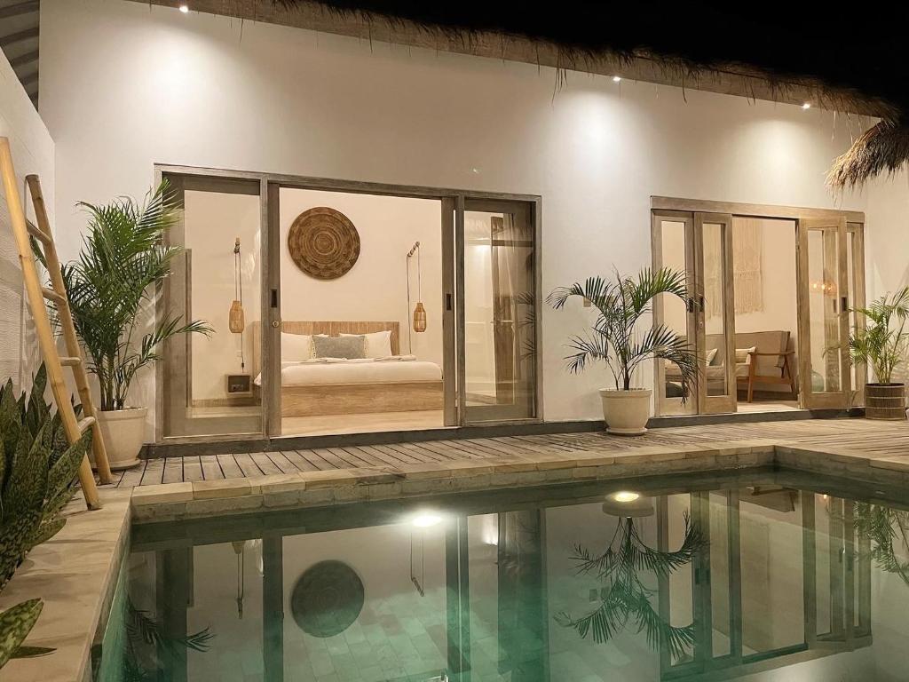 a house with a swimming pool and a bedroom at Mimpi Villa - Gili Air in Gili Air