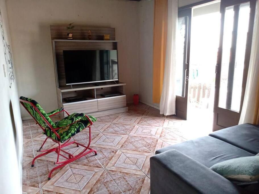 - un salon avec un canapé et une télévision dans l'établissement Casa linda e aconchegante para hóspedes.(Studio), à Joinville