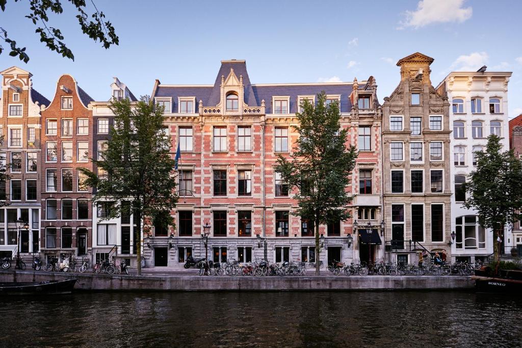 a group of buildings in front of a river at The Hoxton, Amsterdam in Amsterdam