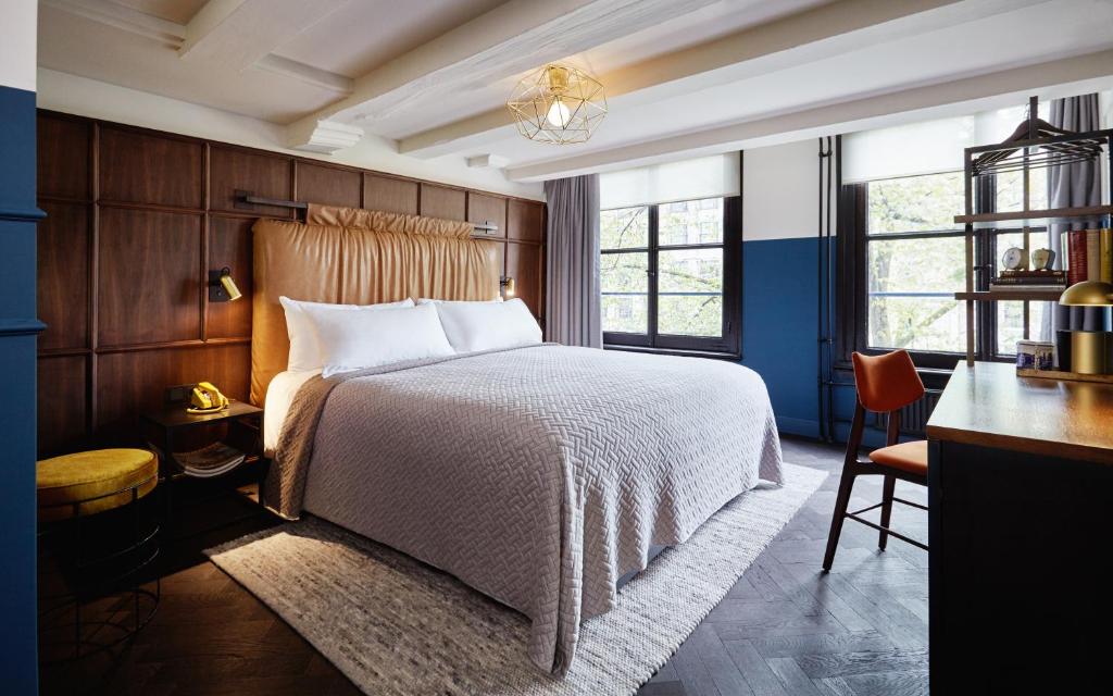 a bedroom with a bed and a desk and a chair at The Hoxton, Amsterdam in Amsterdam