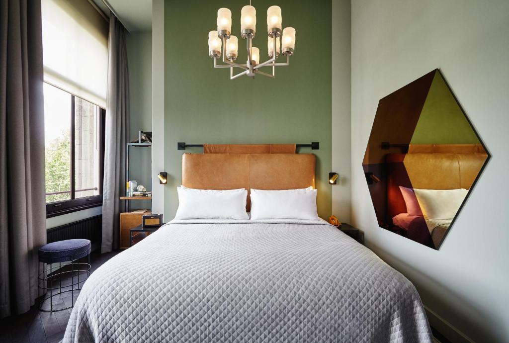 a bedroom with a bed and a chandelier at The Hoxton, Amsterdam in Amsterdam