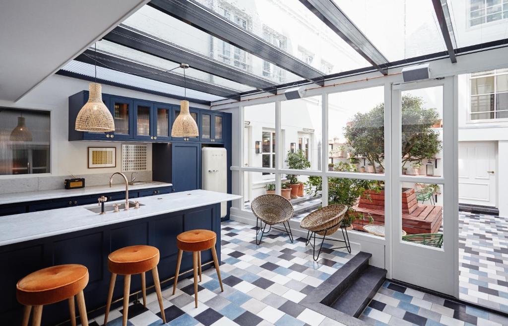 a kitchen with blue cabinets and stools at The Hoxton, Amsterdam in Amsterdam