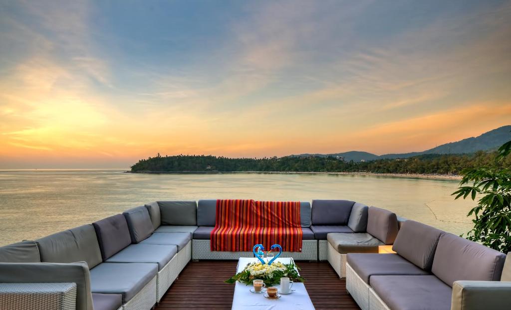 a couch sitting on a dock next to the water at Dream Villa Double Bay Sunset on Andaman Sea in Kata Beach