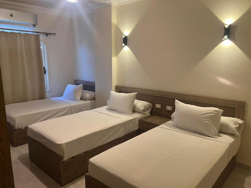 a room with three beds and lights on the wall at MARINA SKY in Hurghada